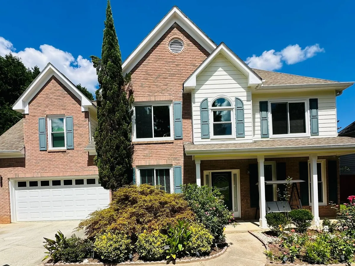 Double hung windows and an arched gable window on a brick and siding home